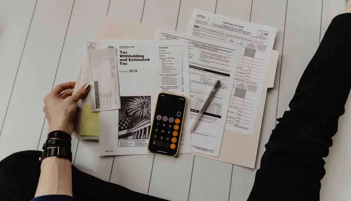 Tax documents and a calculator on a desk, illustrating the 3% lodging tax, 16% IVA, and ISR obligations that apply to Airbnb hosts in Mexico